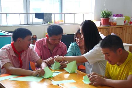 志愿者在教小朋友们折纸